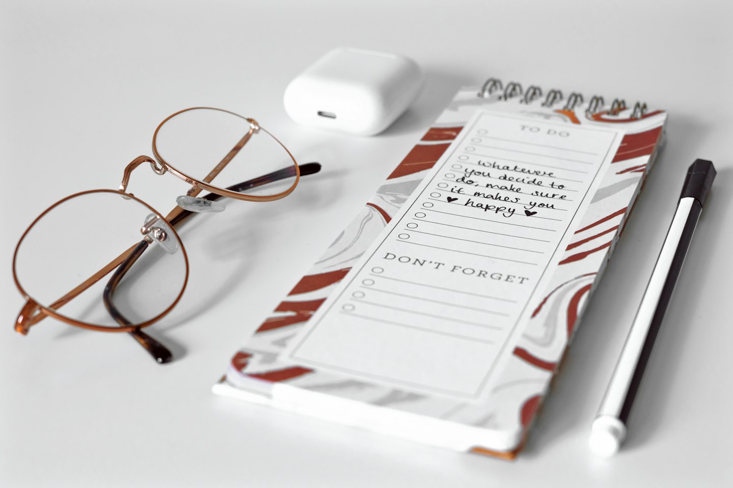 Minimalistische Schreibtischutensilien mit Brille und To-Do-Liste.