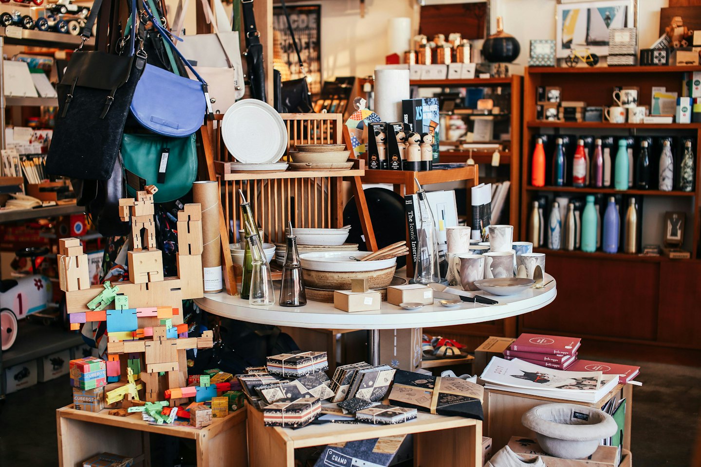 Holzregale und Tisch mit kuratierten Haushaltswaren in einer Boutique.